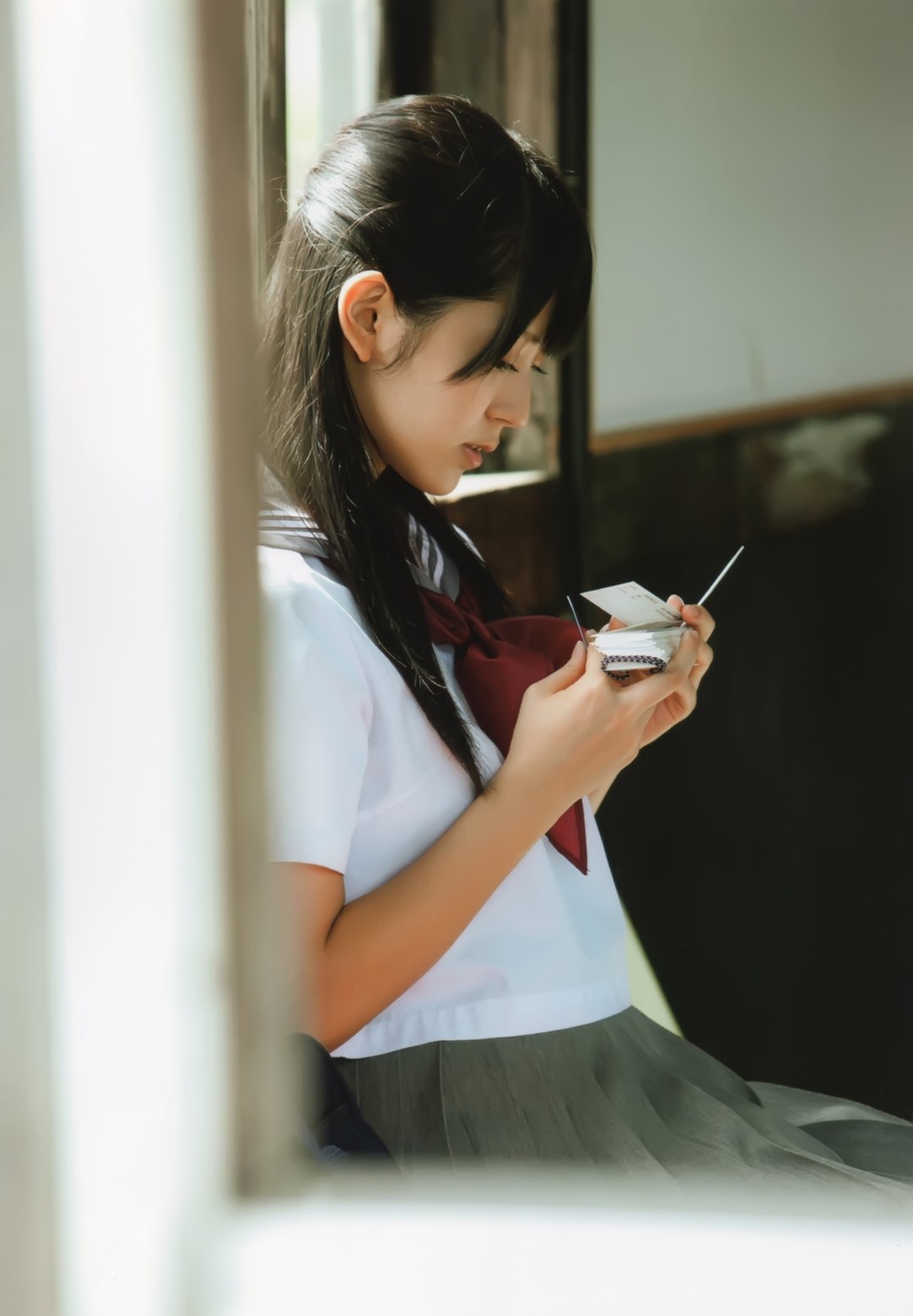 铃木爱理《卒業》内页 车厢窗边低头拆一盒小东西